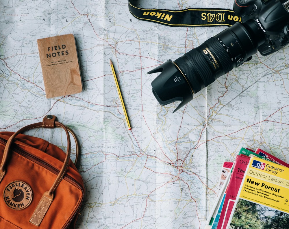 A map, camera and travel essentials arranged for trip planning